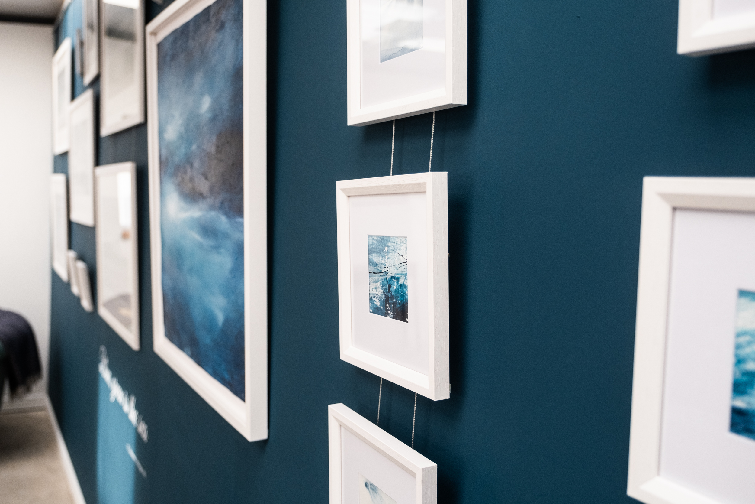 Gallery walls with sea paintings in ink of the Isle of Harris