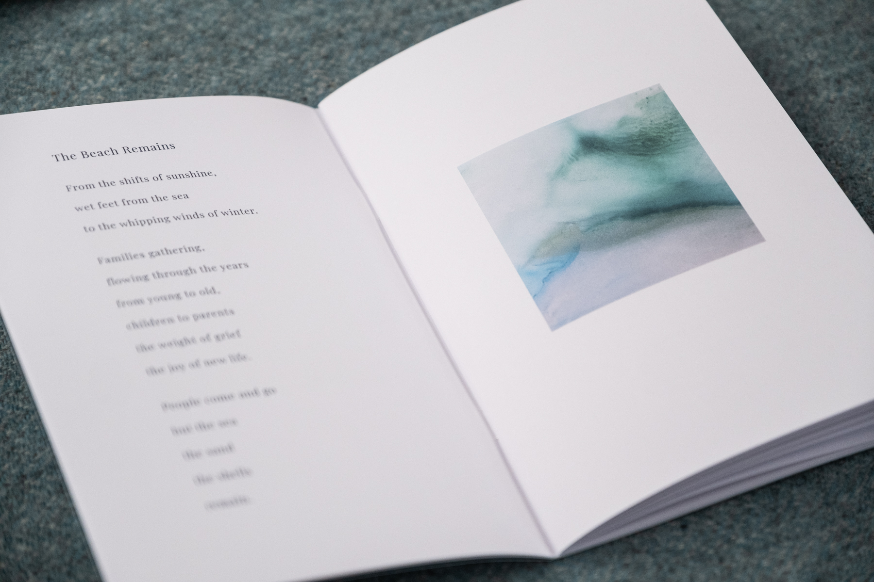 Open spread of Shaped by the Sea showing the poem The Beach Remains alongside a soft teal watercolour painting