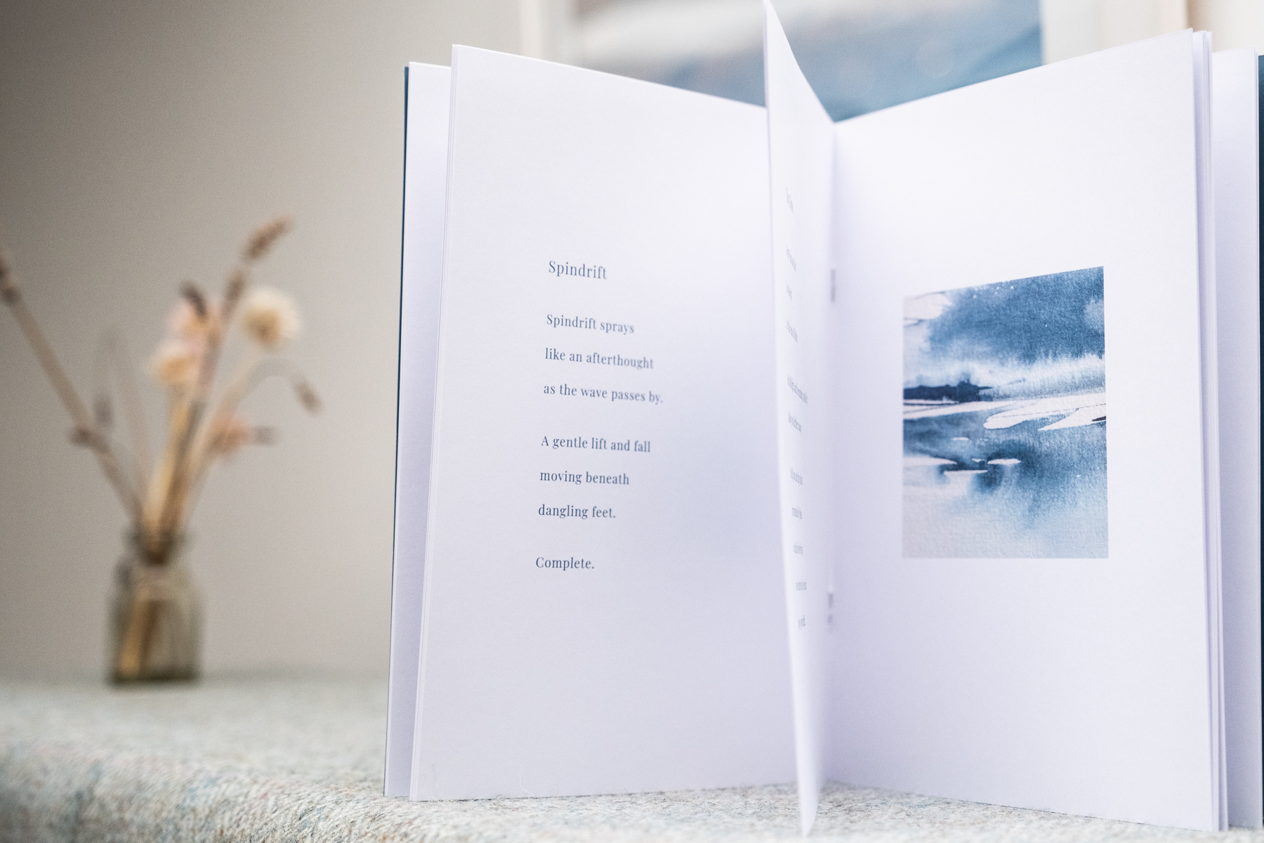 Inside spread of Shaped by the Sea showing the poem Spindrift alongside a watercolour seascape painting