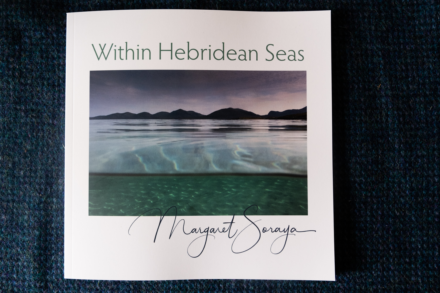 Within Hebridean Seas photography book by Margaret Soraya, showing an underwater and above water split photograph of the Isle of Harris coastline