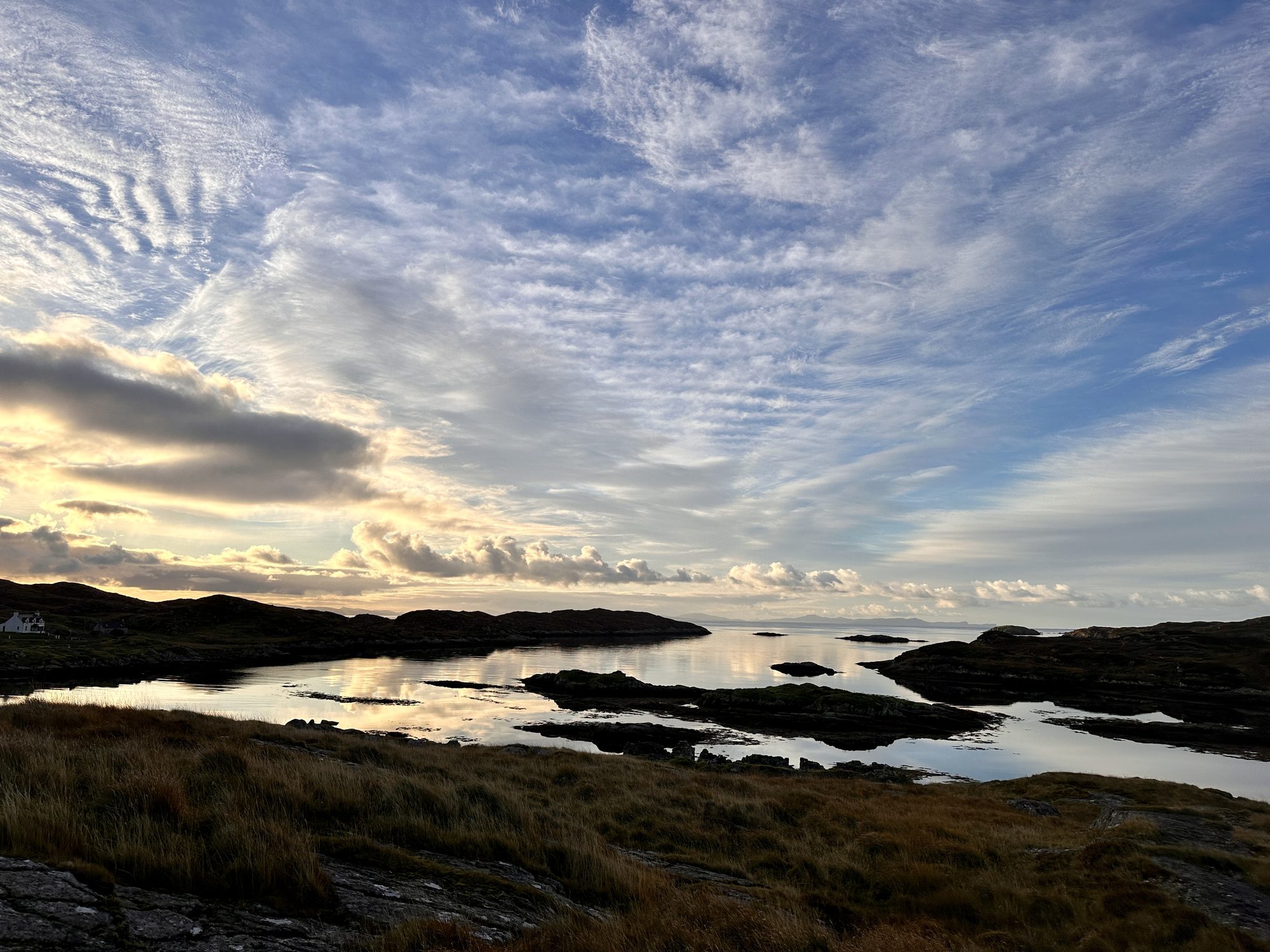 Wispy clouds over sea inlets and rocky islands in the Bays of Harris on a still autumn morning
