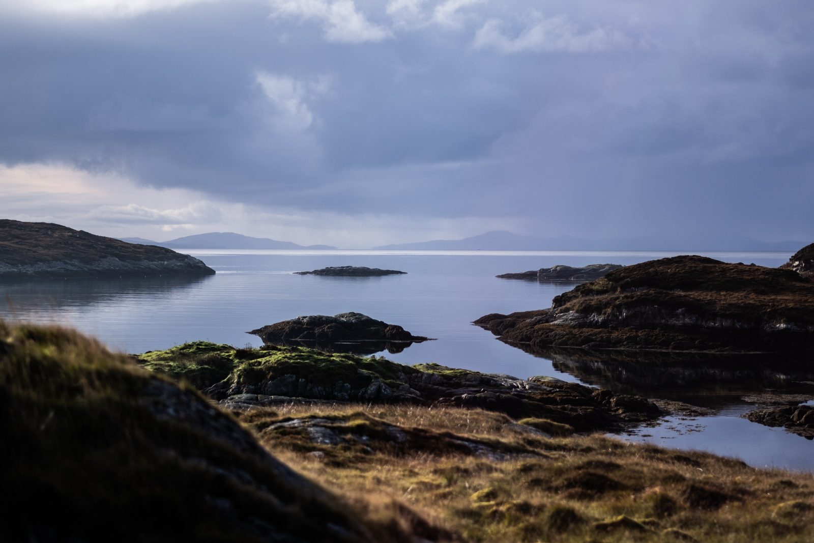 View across a calm sea loch and small islands from a croft in the Bays of Harris